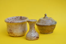 Load image into Gallery viewer, Three individual wooden pieces. A bowl, a vase and a bowl with a lid on a yellow background.