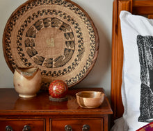 Load image into Gallery viewer, Three hand turned wooden bowls. The smallest bowl has a red wooden ball sitting in it. They are on a bedside table. The edge of a black and white pillow can be seen and there is a large round African basket propped against the wall in the background.