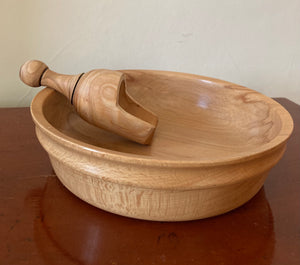 Wooden Bowl with Wooden Scoop on a shiny wooden sidetable. 
