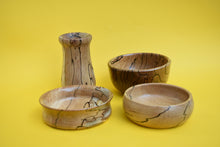 Load image into Gallery viewer, Four stylish wooden bowls on a yellow background.