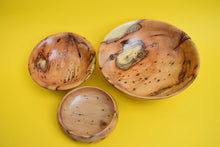 Load image into Gallery viewer, A birds eye view of three wooden bowls of different sizes on a yellow background.