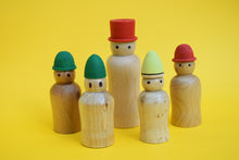 Load image into Gallery viewer, Five wooden peg people of different heights on a yellow background. 
