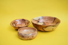 Load image into Gallery viewer, Three wooden bowls of different sizes on a yellow background. 
