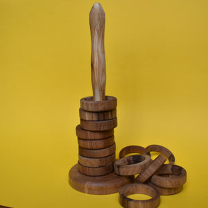 Set of 15 wooden stacking rings with some of the rings removed and placed next to the pole. On a yellow background. - The Sidlaw Hare