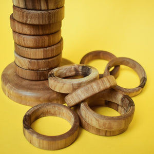 A close up shot of some of the wooden rings and the base of the stacking pole on a yellow background. - The Sidlaw Hare